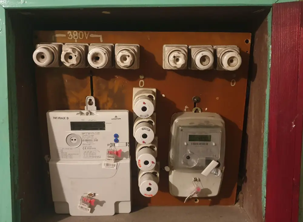 Stara rozdzielnica z bezpiecznikami porcelanowymi i licznikami energii
